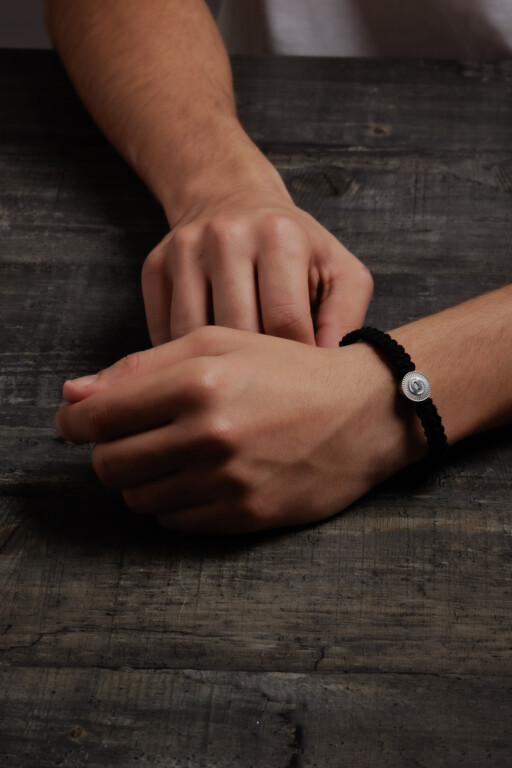 Joolet Βραχιόλι με μαύρο κορδόνι, φορεμένο σε ανδρικό χέρι. Ασήμι 925. Συνδυάζεται με όλα τα Joollions.