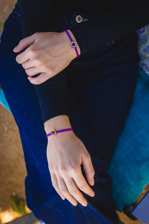 Joolet Bracelets (Βραχιόλια με λεπτό κορδόνι) σε γυναικείο χέρι. Μωβ χρώμα. Ασήμι 925. Συνδυάζονται με όλα τα Joollions.